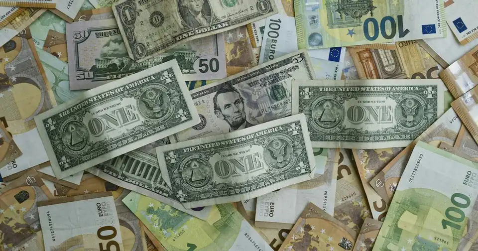Banknoty dolarowe i euro rozsypane obok siebie