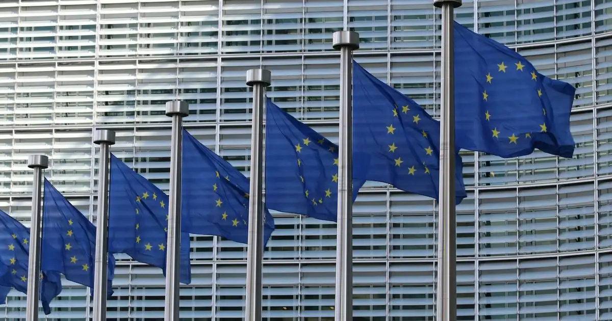 Flagi Unii Europejskiej przed budynkiem instytucji europejskiej